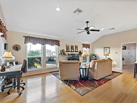 Open living/kitchen/dining concept with wood flooring.
