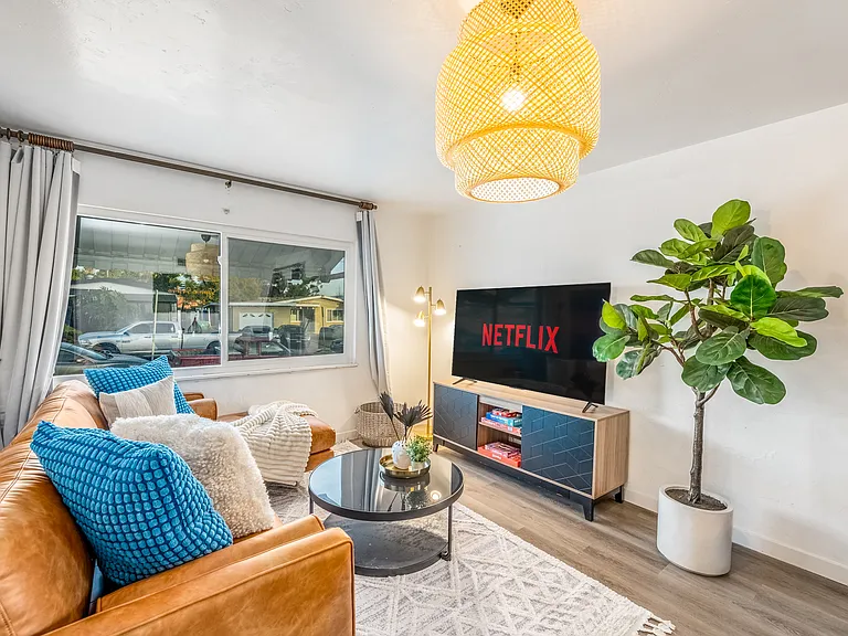 Sleek flat-screen TV takes center stage, inviting guests to unwind and indulge in endless entertainment. The TV is large, ensuring clear, high-definition viewing from anywhere in the room.