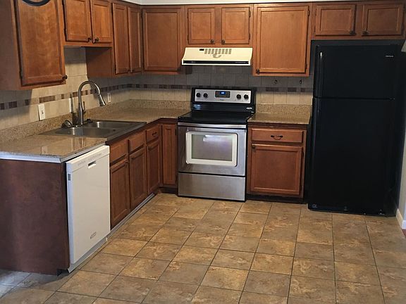 Kitchen with tile floor. Dishwasher, stove, refrigerator, food disposal.