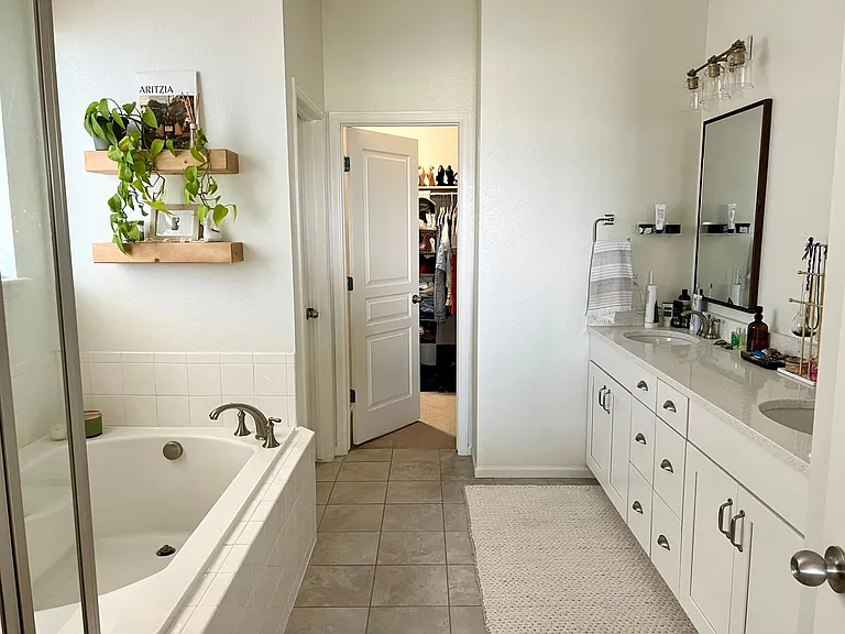 Primary bathroom with water-closet, double vanity, bathtub, shower and walk-in closet
