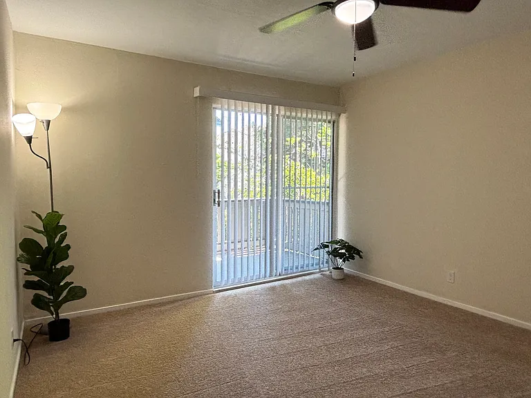 Unit 210B:
Primary Bedroom with Views of Trees from Balcony