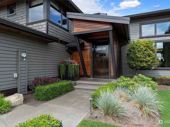 Stunning entry featuring steel supports, new siding, appealing stone accents and meticulous landscaping>