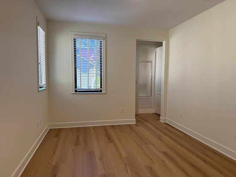 Spacious Bedroom #2 features multiple windows, vinyl flooring, walk-in closet, a separate bathroom sink and share a Jack-and-Jill style bathroom for the bathtub and toilet.