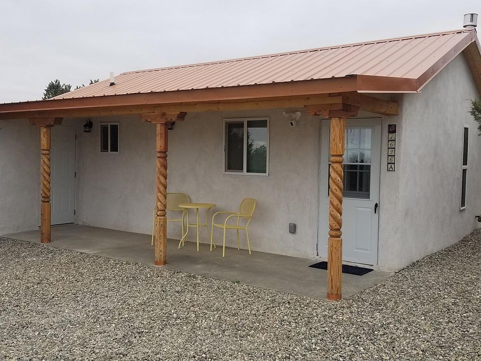 covered porch with patio table and chairs. attached matching door lock storage shed