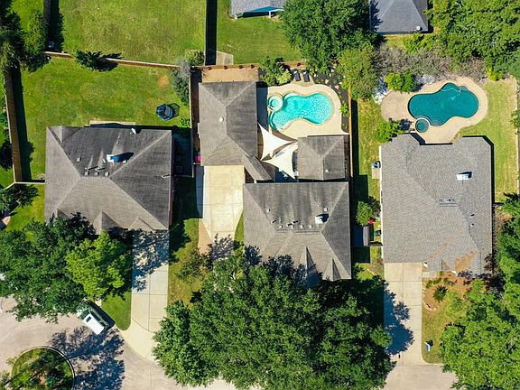 This aerial shot shows a wonderful birds eye view overlooking the home. The driveway starts as a single-wide becoming a double-wide closer to the 4 car garage. That's right, the garage holds 4 cars!