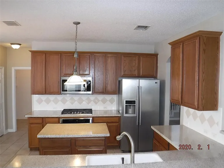 KITCHEN WITH SS APPLS AND GRANITE COUNTERS, TILED FLOORS.