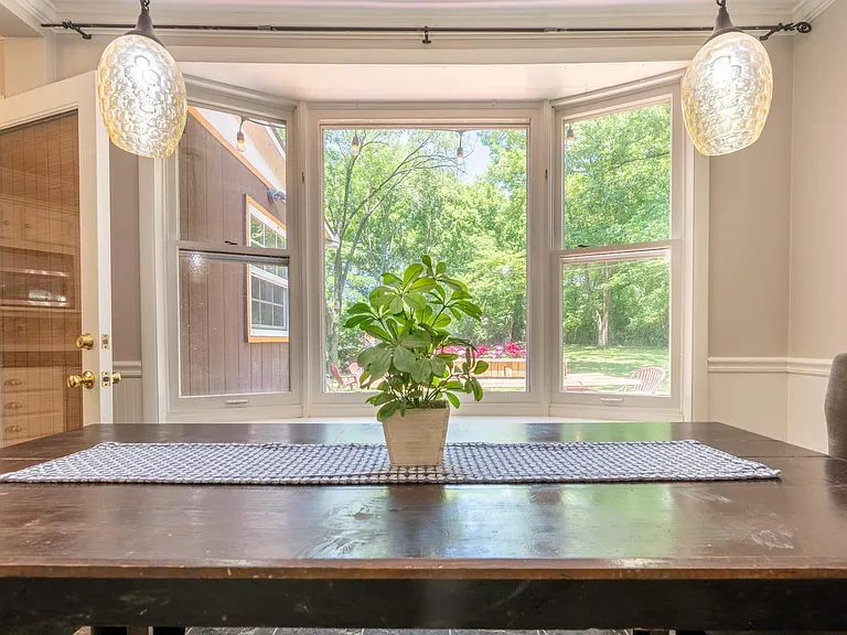 Large dining table and bay window.
