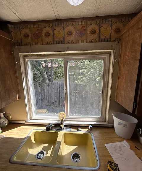 View of trees and fenced in area from the kitchen window.