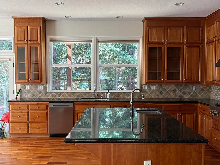 Large kitchen window overlooks private sideyard
