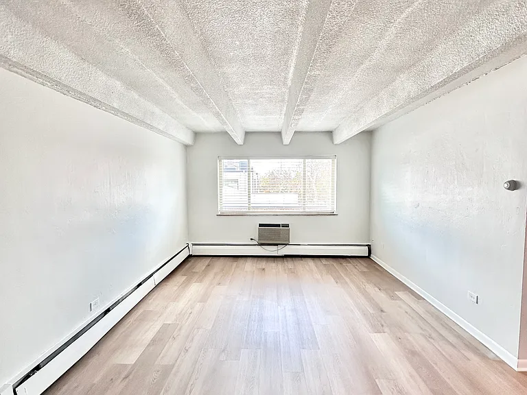 Bright and spacious room with modern wood flooring and large window inviting natural light. Bright and spacious room with modern wood flooring and large window inviting natural light.