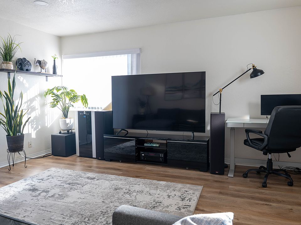 Livingroom equipped with 75 inch Samsung HD TV, home theater, portable AC unit and stand-up desk