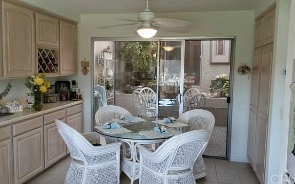 In kitchen dining area and a view of the ample counter space and cabinets with built in wine rack all that open up to the atrium