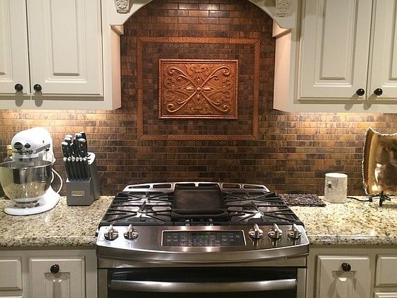 Gas range, custom copper metal tile backsplash.