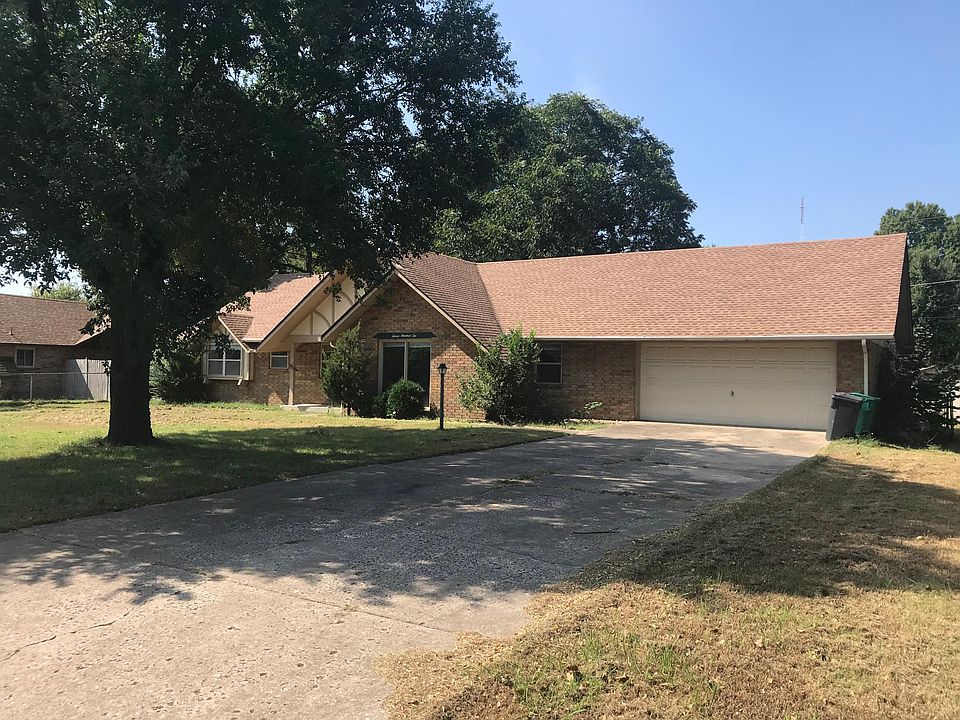 Front of home with large shade tree and 2 car garage.