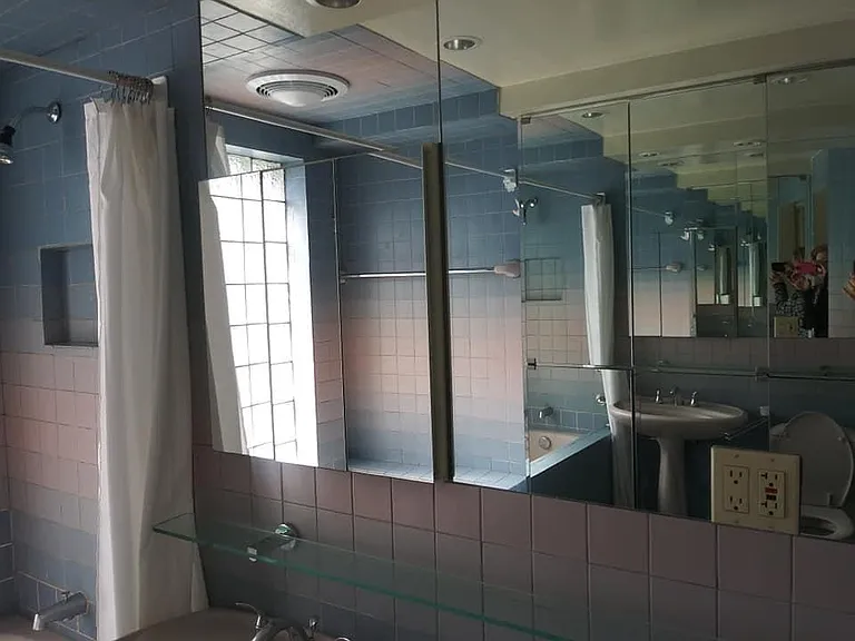 Bathroom with mirrored storage and mirrored and glass cabinetry