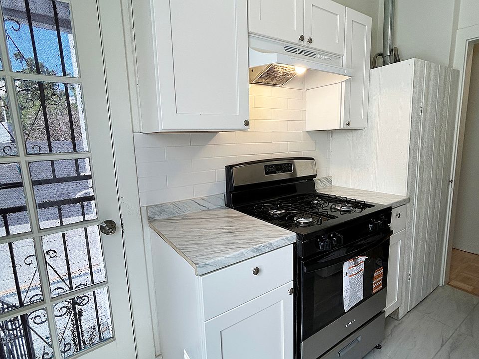 Renovated kitchen with new oven, cabinets, flooring, and water heater.
