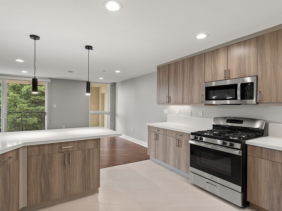 Designer kitchens with quartz countertops, stainless steel appliances and a breakfast bar
