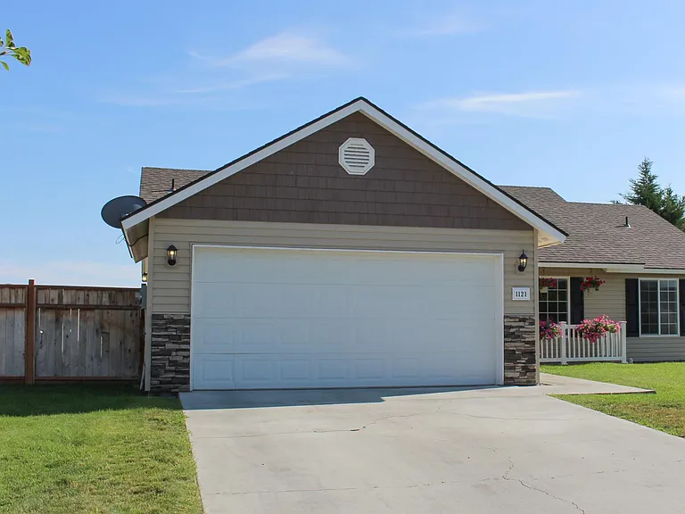 Large front yard with a covered porch and two car garage
