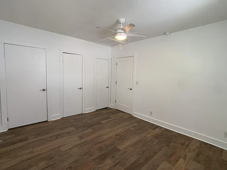 Bedroom looking back towards the entrance door (far right). Other doors are 2 closets and bathroom.