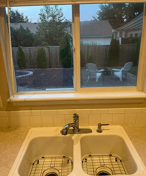 Look out into garden, fire pit and back yard right from your kitchen window. Plus, stainless grids to protect the sink and make clean up easy!