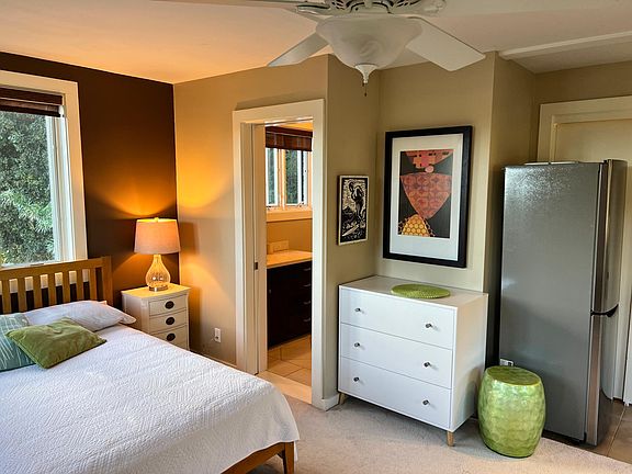 Bed area, bathroom, and fridge