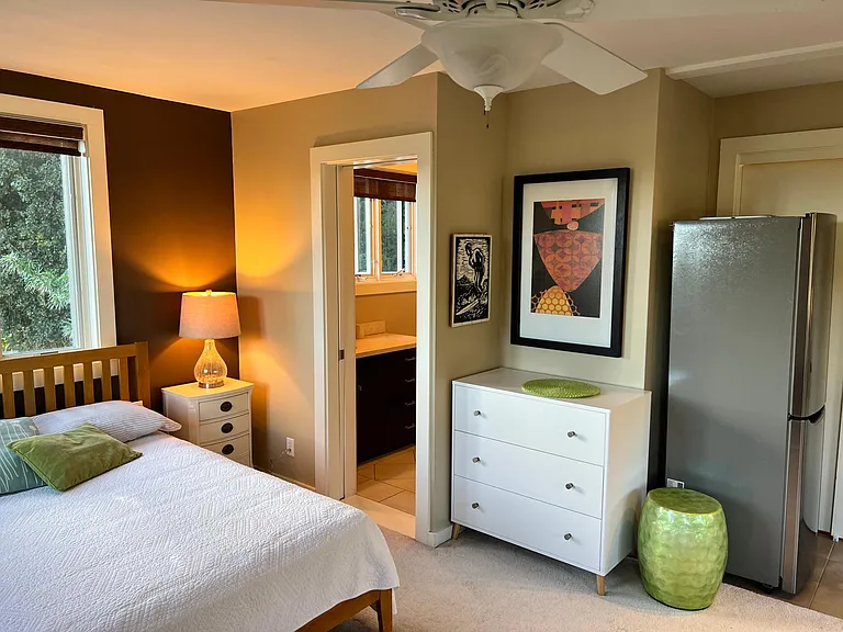 Bed area, bathroom, and fridge