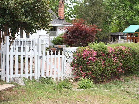 Parking area and entrance to side of house in a fenced in si