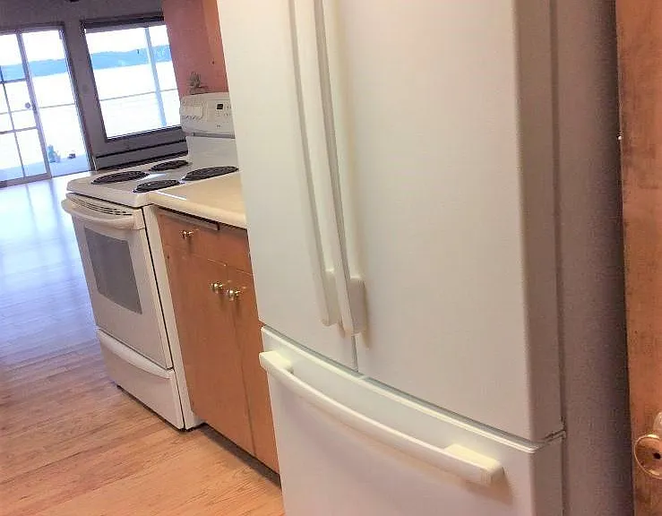 refrigerator and stove with view towards sliding glass door