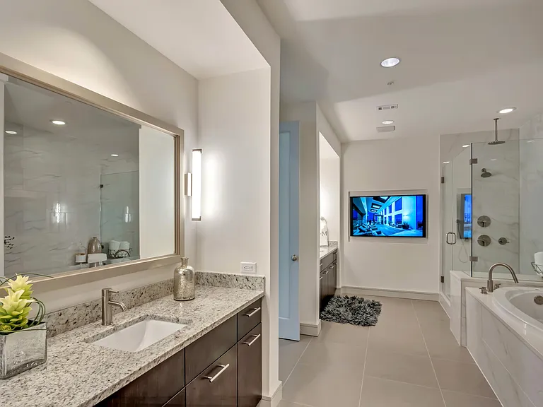 Spa-like bathrooms feature separate vanities, built-in TVs, soaking tubs and frameless glass showers.