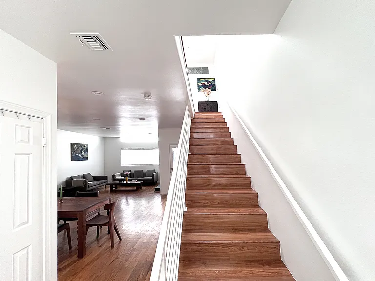 Modern stairs featuring a clean design and premium wood laminate, seamlessly connecting the living room to the upper level.