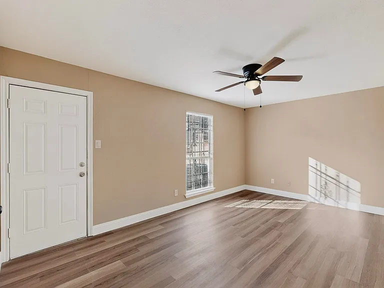 Spare room with wood finished floors and a ceiling fan