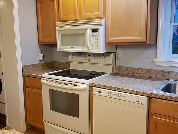 Dishwasher, stove and overhead microwave. Numerous cupboards for storage.