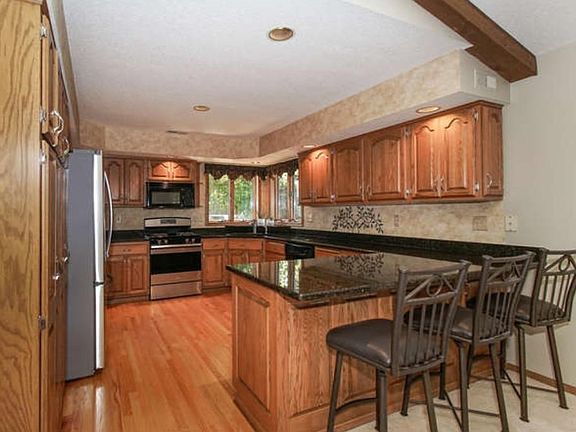 Spacious Kitchen has granite counter tops, Gleaming original hardwood floors,stainless appliances, plenty of storage cabinets with pull out shelving and recessed lighting.
Two corner windows above the sink allow  viewing of the back yard .