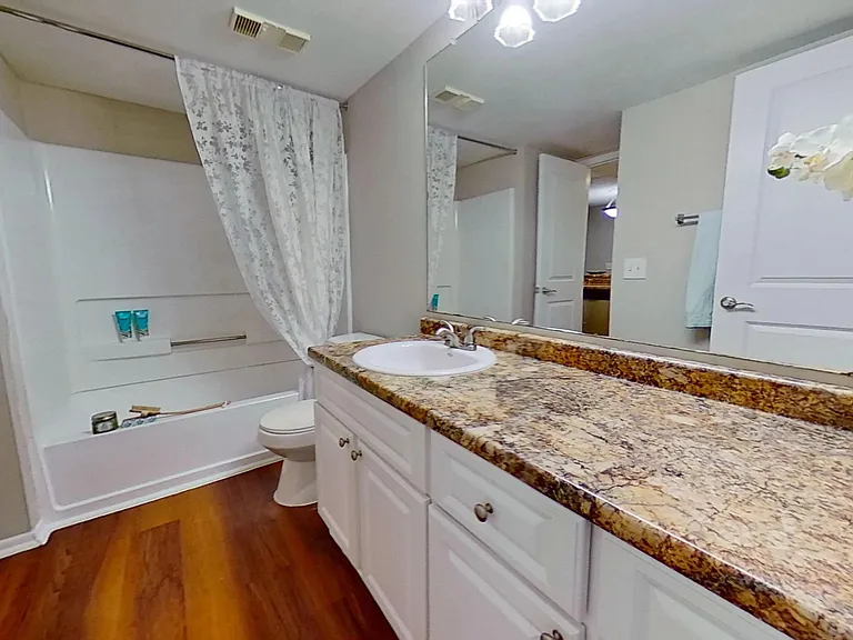 Enjoy the comfort of a beautifully designed bathroom in The Newport Autograph floor plan featuring elegant granite countertops, ample storage space, and a full-size tub for ultimate relaxation.