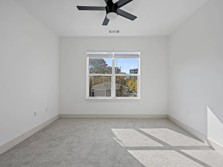 Tranquil Sleeping Space with Natural Light and Modern Fan