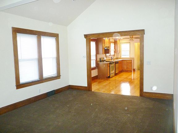 living room view from front door. living room is carpeted. living room leads into the Kitchen.