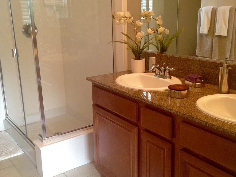 Bathroom with double vanity, tile flooring and walk-in shower at Serenata Townhomes in San Diego, California.