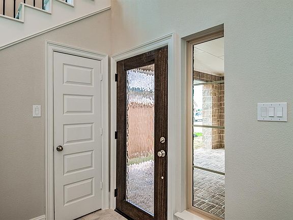 This beautiful front door with glass will lead you to your lovely foyer. You will be greeted with tile floors, large windows with privacy blinds, and high ceilings.