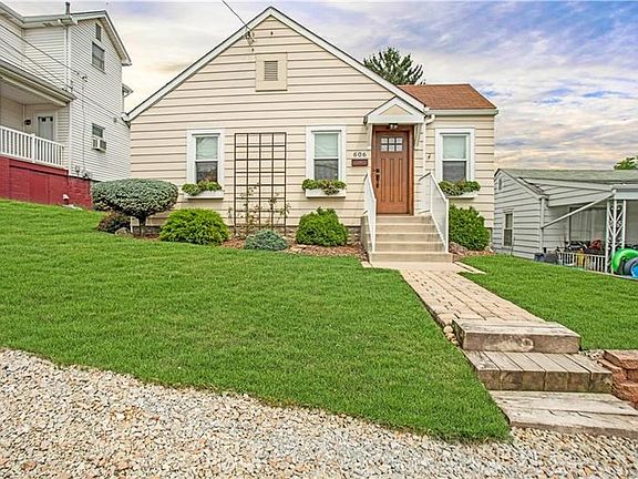 Another view of EXTERIOR FRONT with excellent bird's eye view of lawn, metal trellis and paver walkway.