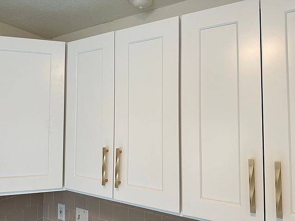 Brand new all white cabinets with gold color cabinet pulls.