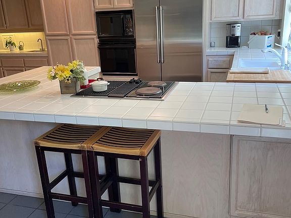 Kitchen with large GE Cafe Refrigerator / Freezer and new dishwasher. Bar sink area is also pictured.