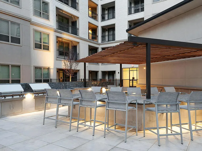Outdoor Grilling Stations Under Pergola with Granite Dining Counters