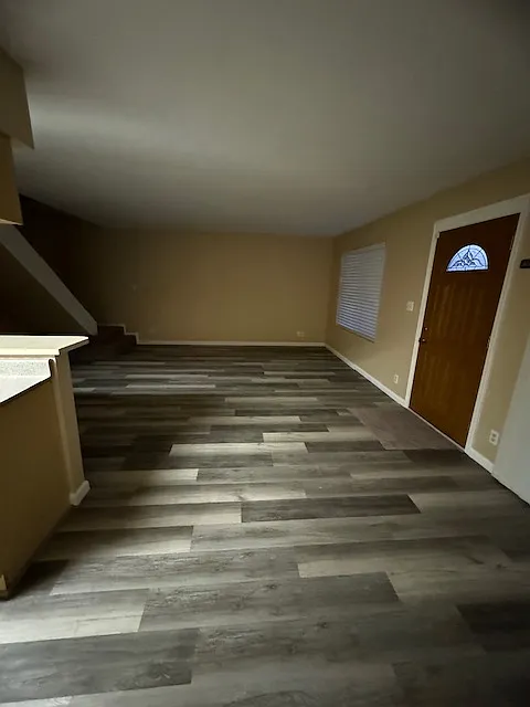Open living room. Front door on the right.