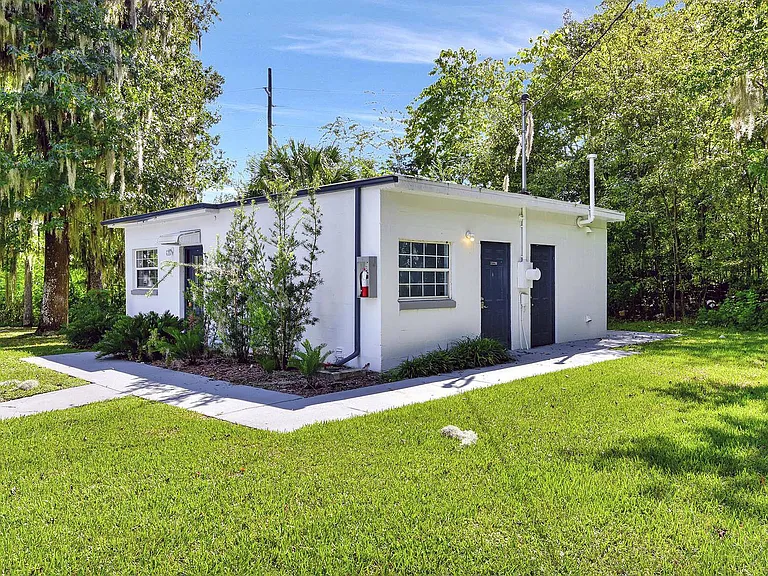 Embrace serene living in this charming cottage, nestled in vibrant green surroundings.