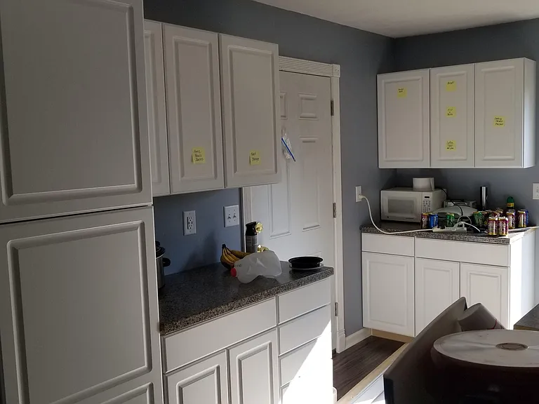 Eat-in kitchen with generous white cabinetry, ample counters, and convenient space for small appliances and storage.
