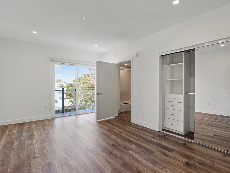 Bedroom with Vinyl Flooring, Large Closet with Built-In Organizers, Bathroom, and Patio