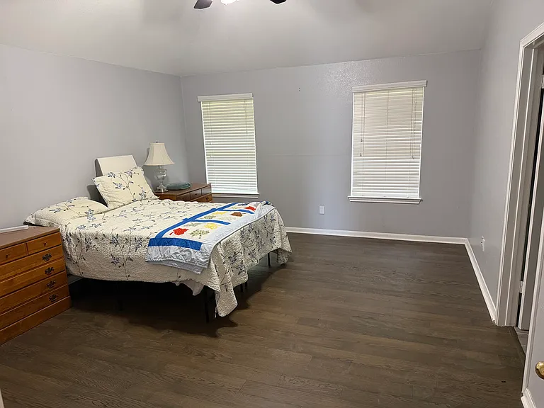 Master Bedroom shown staged with Queen bed for scale. A large, beautiful master suite with attached enormous bathroom and walk in closet. Windows look out into back yard.