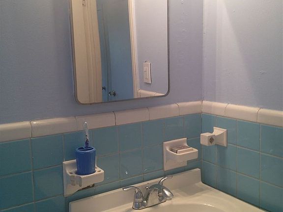Bathroom with three lights over mirror.
