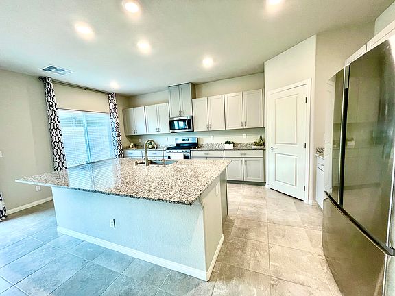 Modern, spacious kitchen with large island, large pantry, plenty of counter space and stainless steel appliances.