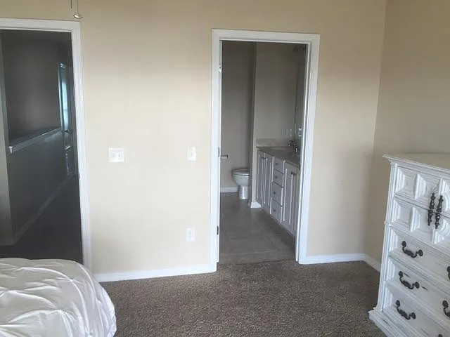 The master bedroom opens up to a full bath with double sinks and a granite countertop.